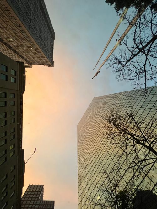 Free Looking up at towering skyscrapers at dusk with cranes and a pastel sky. Stock Photo