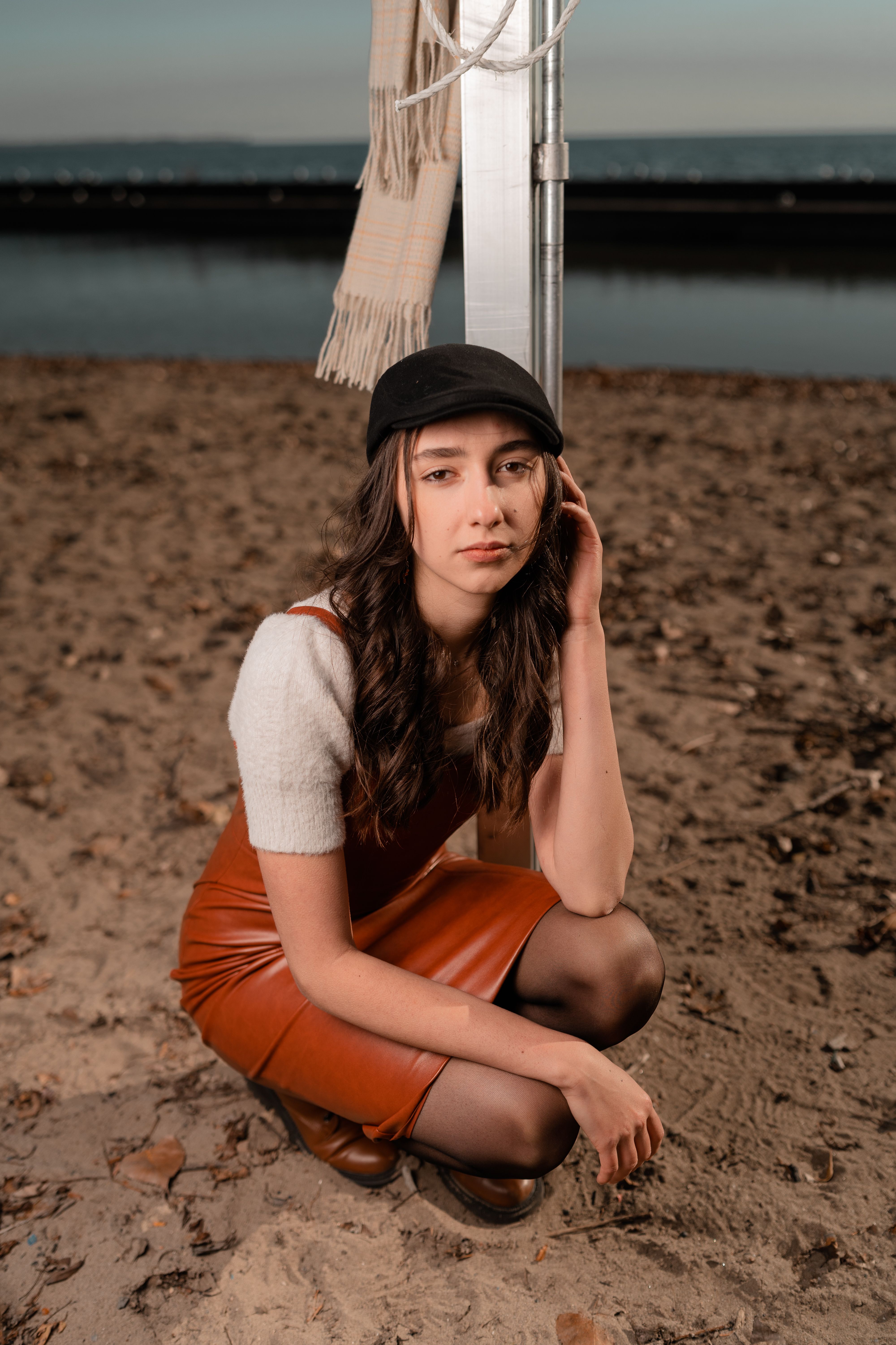 A woman sitting on the beach wearing a hat · Free Stock Photo