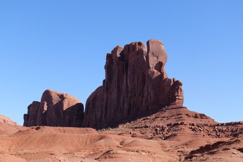 Free Scenic view of Monument Valley's striking rock formations under a clear blue sky. Stock Photo