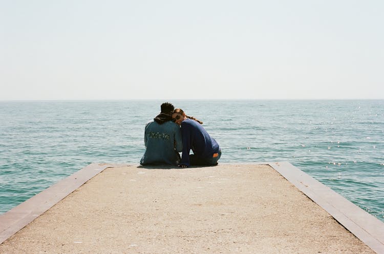 Young Couple On Pier In Sea