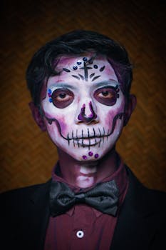 Close-up of a man with intricate sugar skull face paint celebrating traditional Mexican festival.