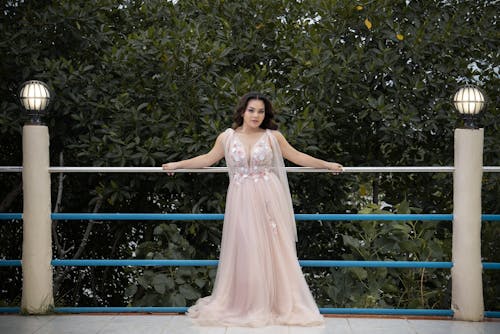 Woman in a Long Pink Gown Standing on the Bridge 