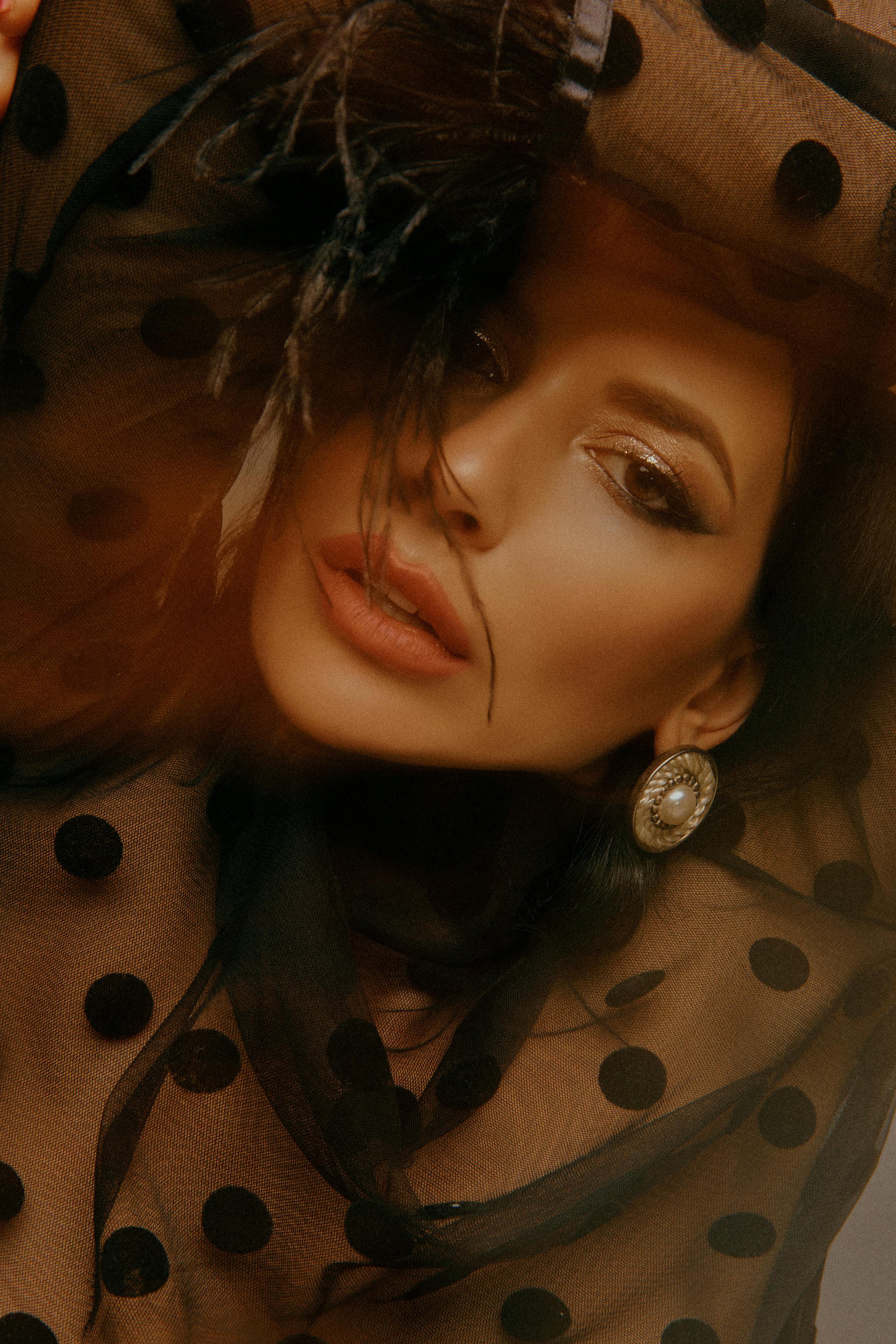 Portrait of a stylish woman in polka dot fashion, elegantly posing with artistic makeup.