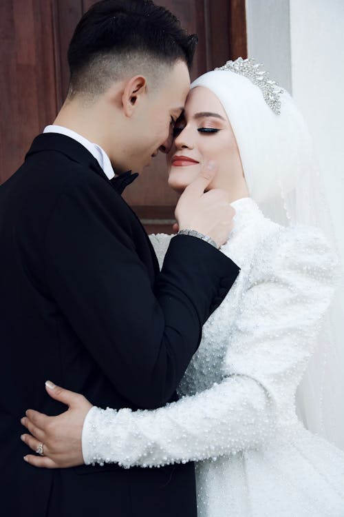 Newlywed Couple Standing Face to Face and Embracing