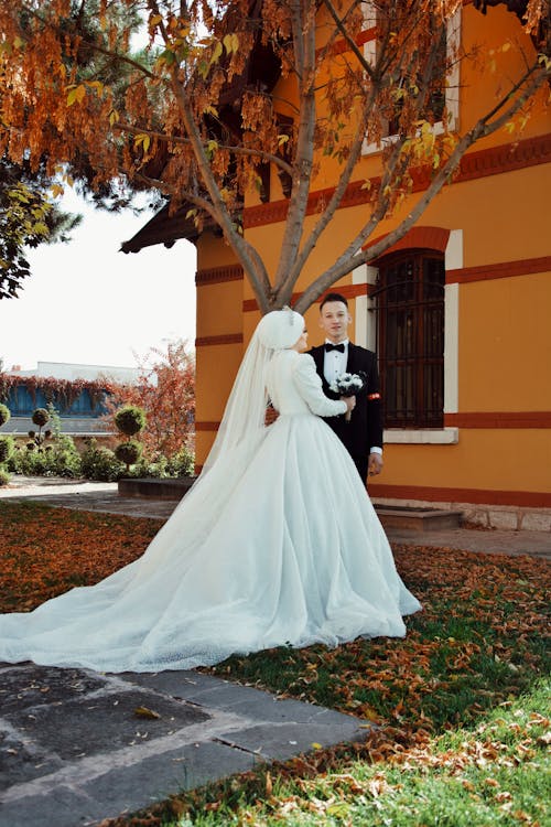 Bride and Groom Standing Outside of a House 