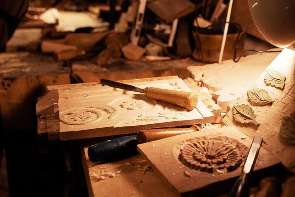 Carving tools and a hand-carved wooden panel on a workbench — photo by Beyzaa Yurtkuran on Pexels