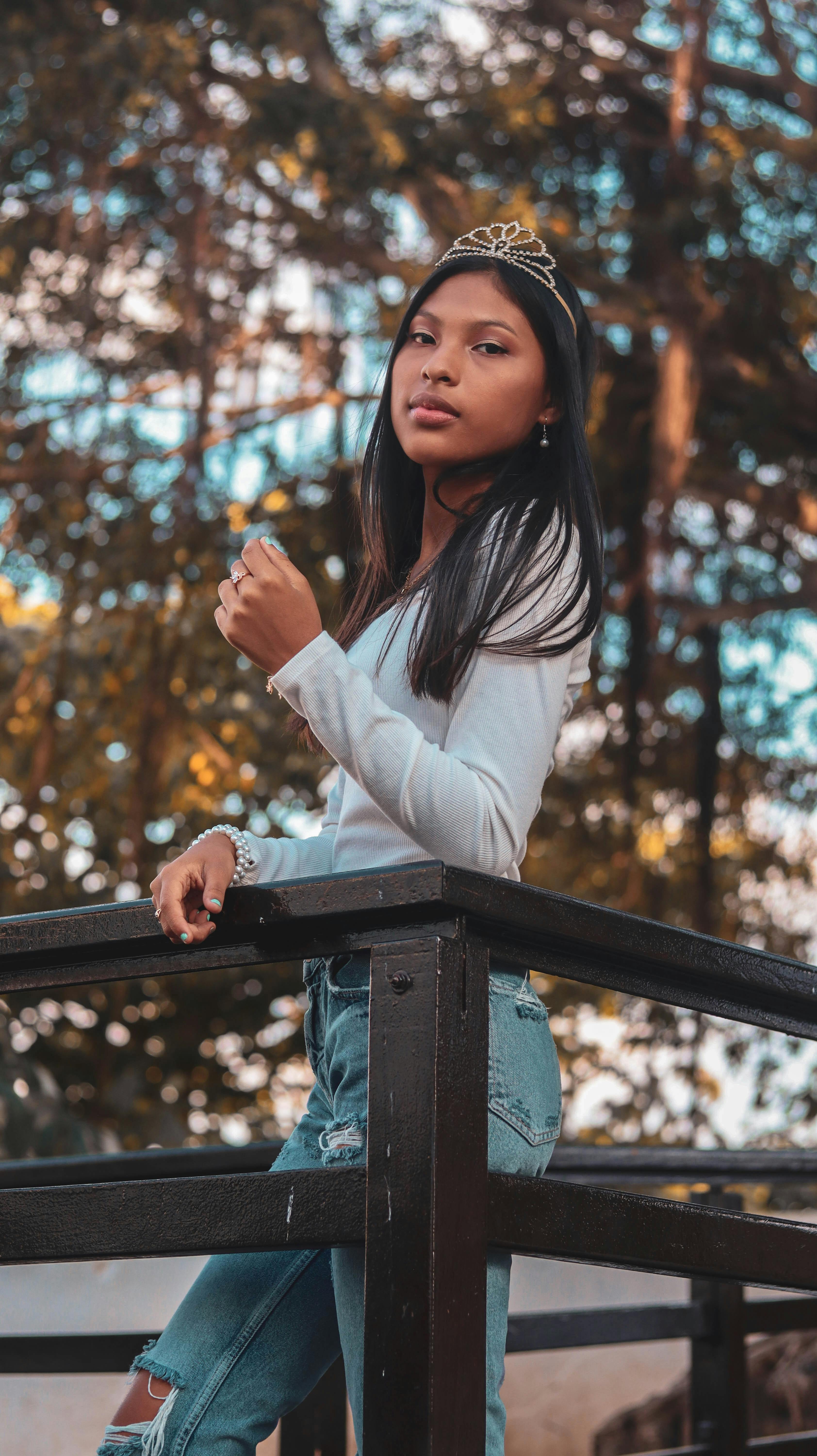 Portrait of a young woman in casual fashion with a tiara, outdoors in a natural setting.