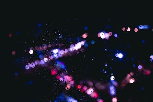 Abstract bokeh with vibrant colors through a rainy window at night.