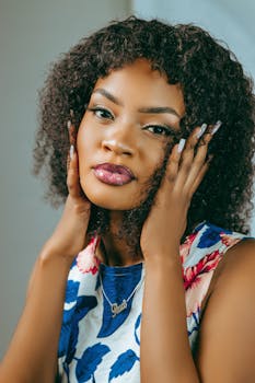 Stylish portrait of a woman with curly hair and floral attire, exuding elegance and charm.
