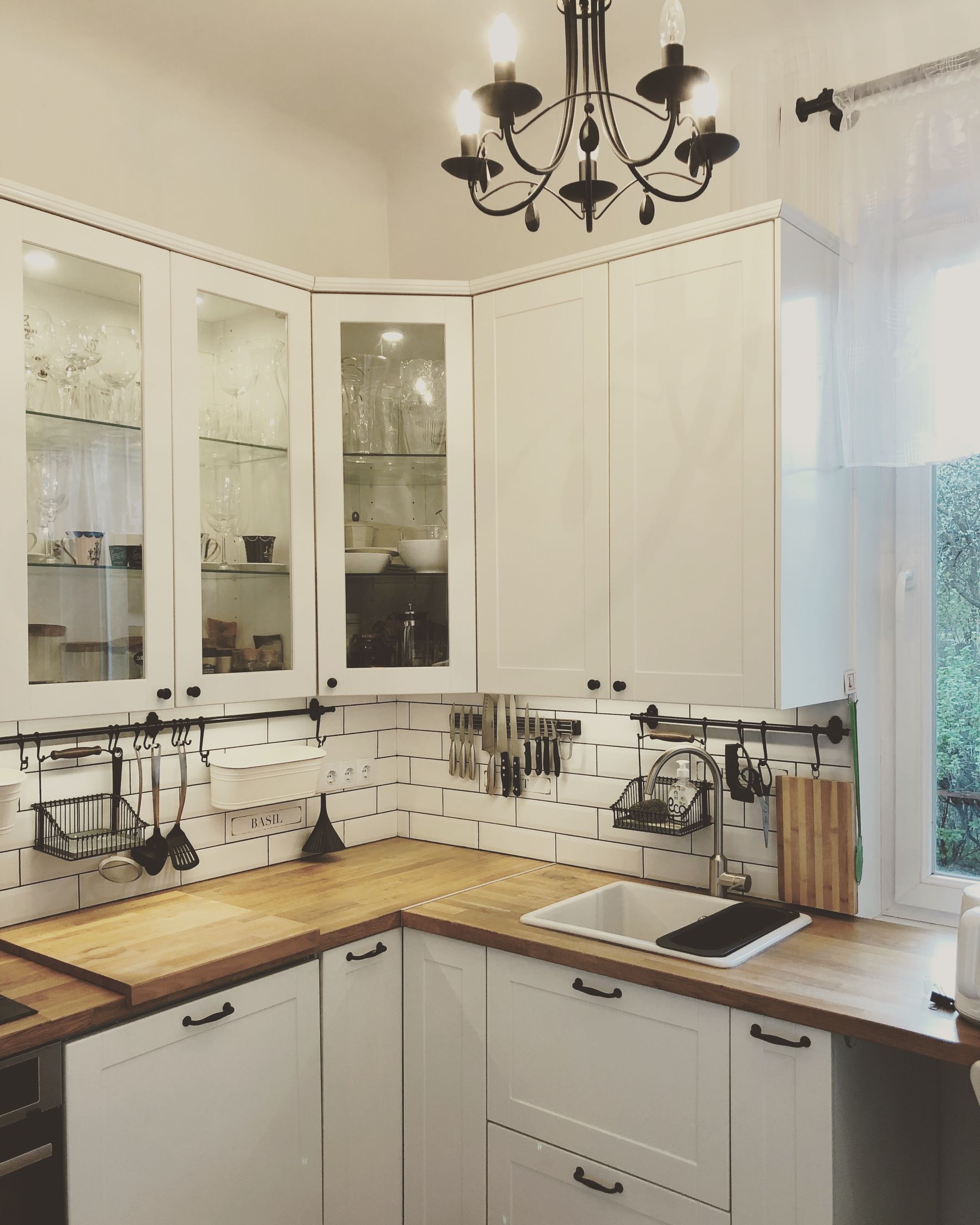 Bright kitchen corner with white cabinetry and a warm wooden countertop