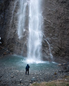 Person standing before a breathtaking waterfall in Hintertux, Austria, in winter.