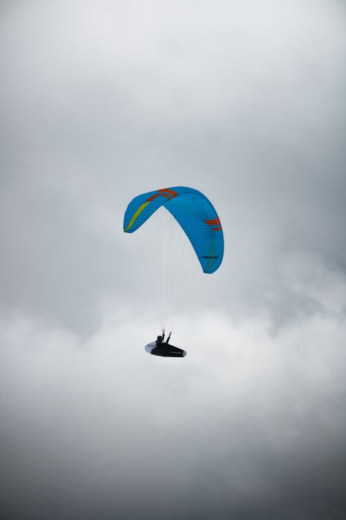 Free A lone paraglider navigating the cloudy skies of Hintertux, Tirol, Austria, showcasing adventure. Stock Photo