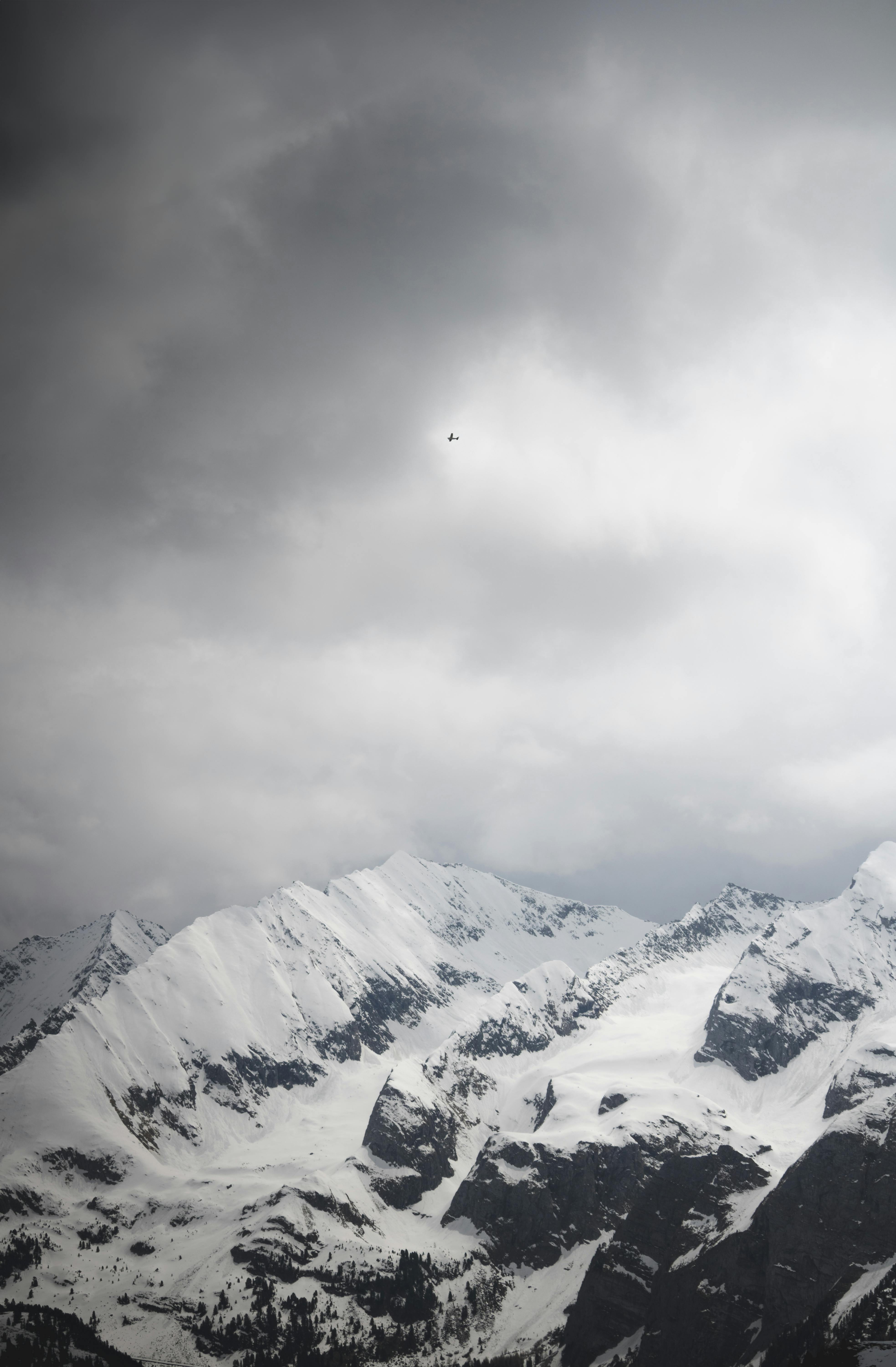 a lone snowboarder is flying through the clouds