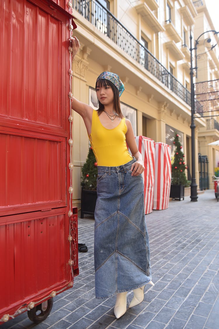 Model Posing In Yellow Bodysuit And Denim Skirt