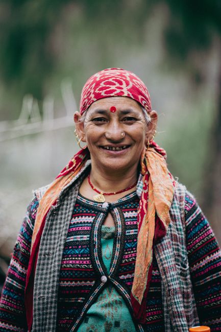 Smiling Indian woman in traditional attire outdoors in Kasol, India.