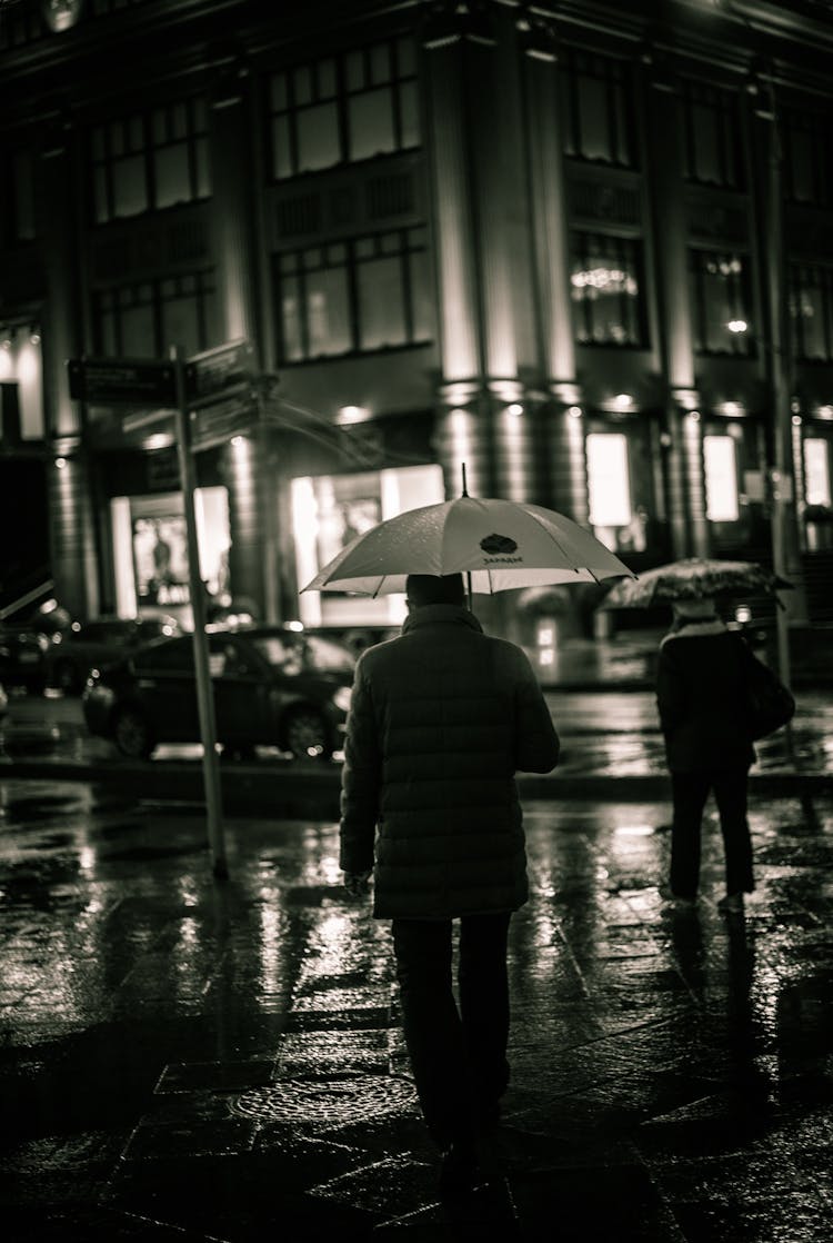 People Walking In City In Rain At Night