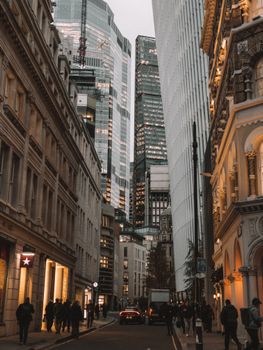 A bustling downtown street lined with modern skyscrapers and historical architecture.