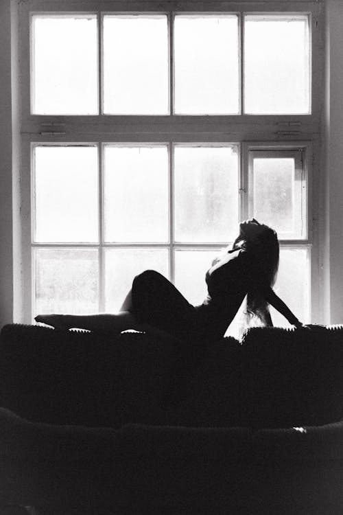 Silhouette of Woman Posing on Sofa in Black and White