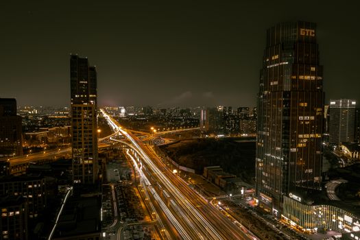 A breathtaking aerial view of a vibrant city at night with illuminated skyscrapers and bustling streets.
