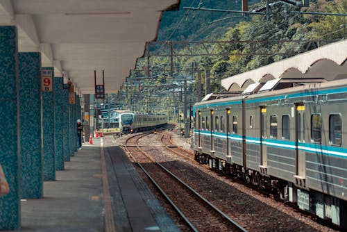 Japanese Trains Arriving at the Train Station Overlooking a Mountain Landscape