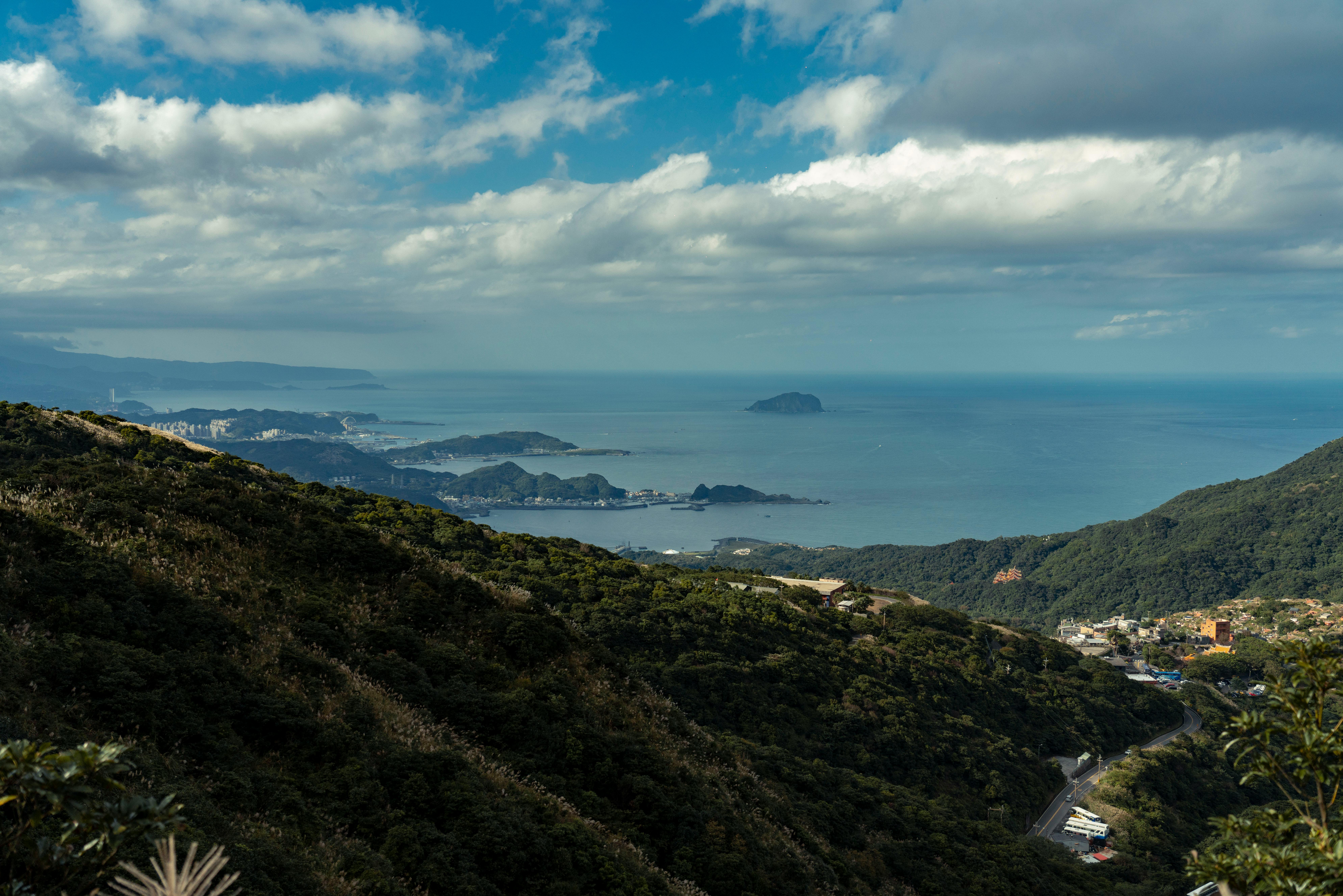 Breathtaking view over lush hills meeting the expansive ocean under a cloudy sky. (Photo: Jimmy Liao)