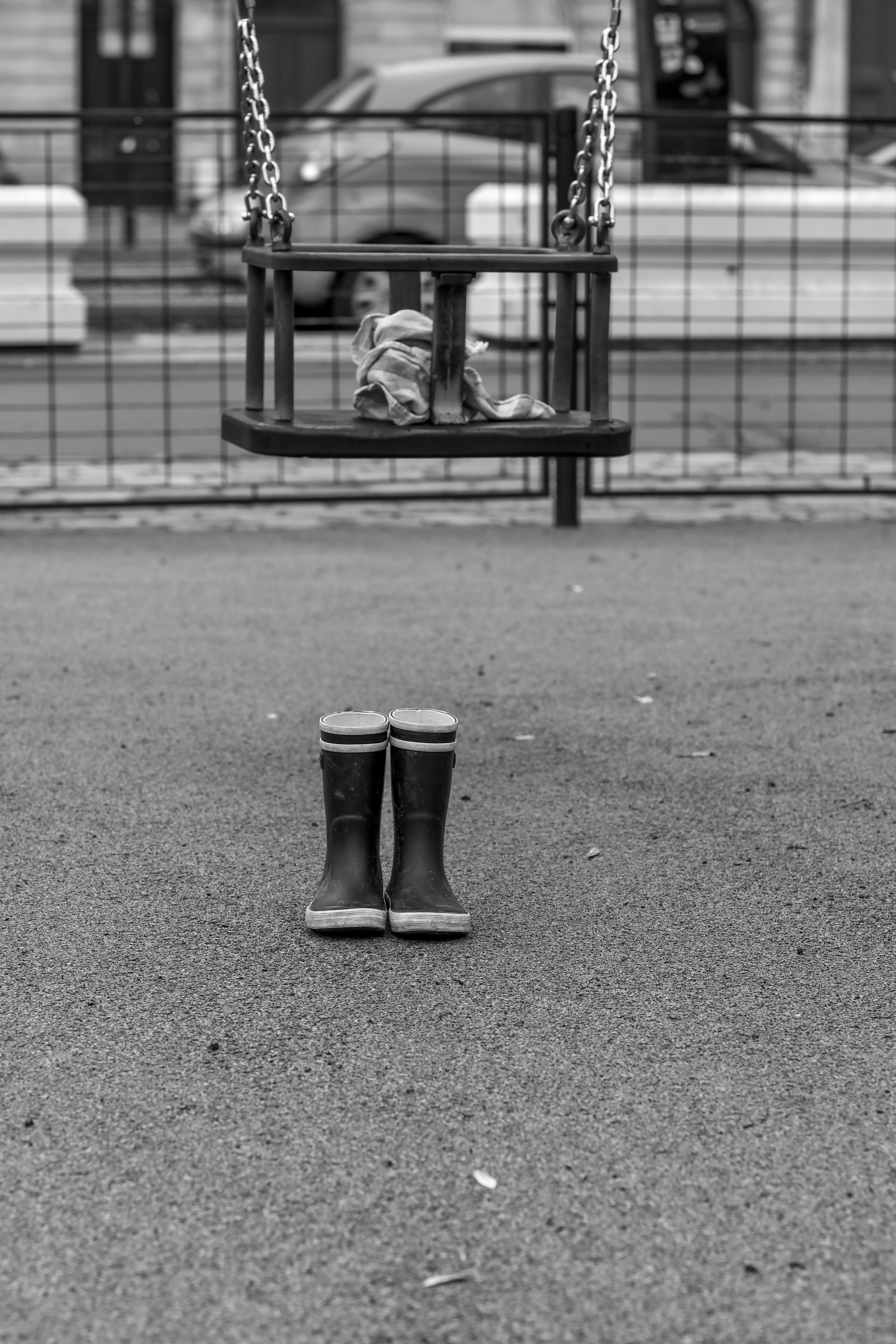 a black and white photo of a child sitting on a swing