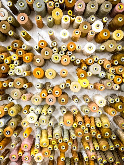 Top view of colorful thread spools meticulously arranged in a vertical pattern.