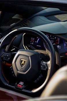 Close-up view of a luxurious Lamborghini sports car steering wheel showcasing elegance and design.