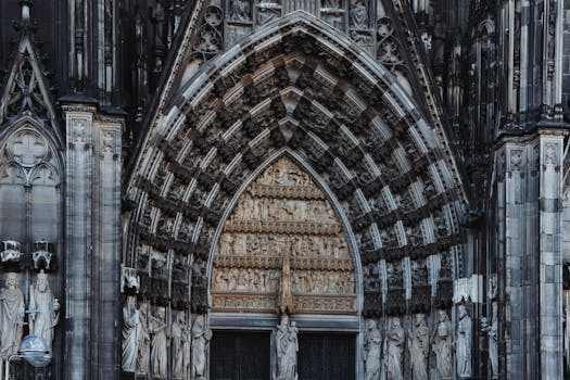 Detailed view of the intricate Gothic entrance of Cologne Cathedral, showcasing religious statues.