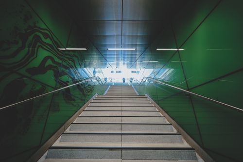 Free Urban subway station with striking green walls leading up from underground. Minimalist design and clean lines. Stock Photo