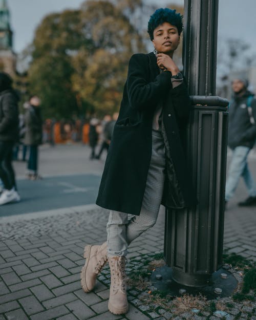 Woman Leaning on Street Lamp