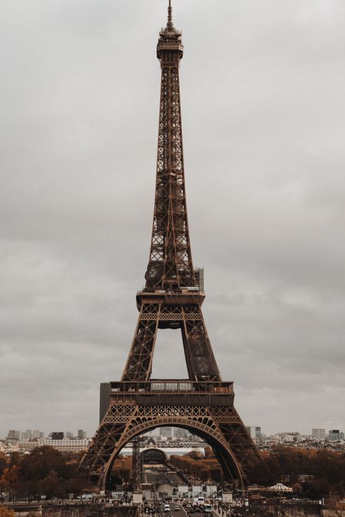 Free Eiffel Tower in Paris with overcast sky and autumn foliage. Stock Photo