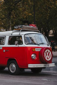 Red vintage Volkswagen bus parked on a city street, showcasing nostalgia and retro style.