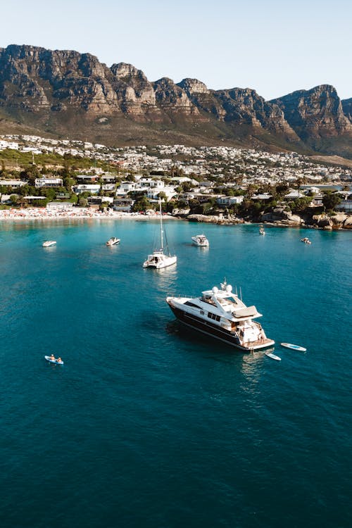 Free Stunning aerial view of a luxury yacht in Camps Bay, Cape Town with mountain backdrop. Stock Photo