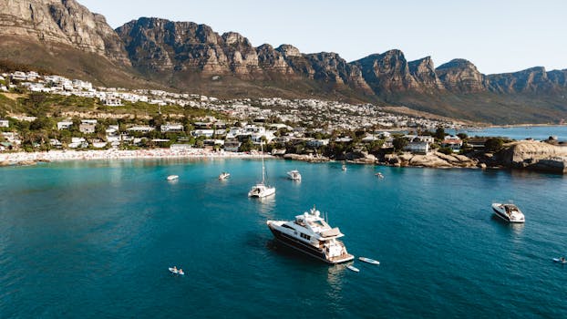 A picturesque view of yachts in Clifton Beach, Cape Town with mountain backdrop.
