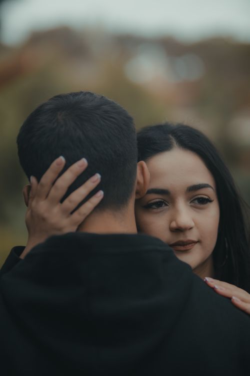 Free A tender moment captured between a couple in a serene outdoor setting. Stock Photo
