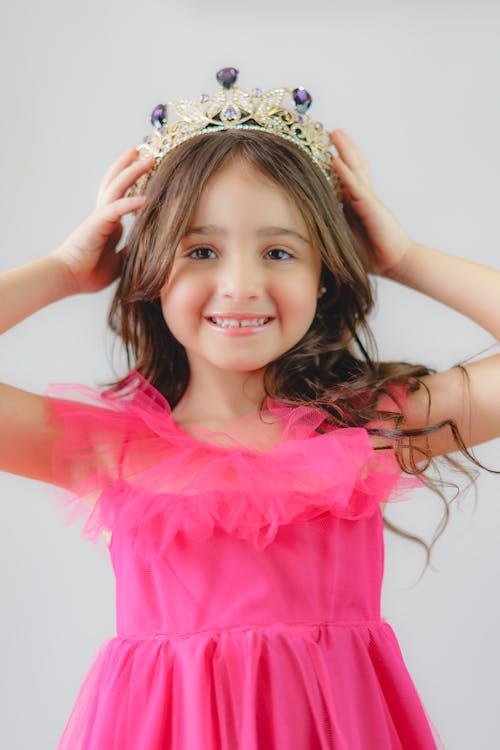A Little Girl Wearing a Pink Dress and a Tiara 
