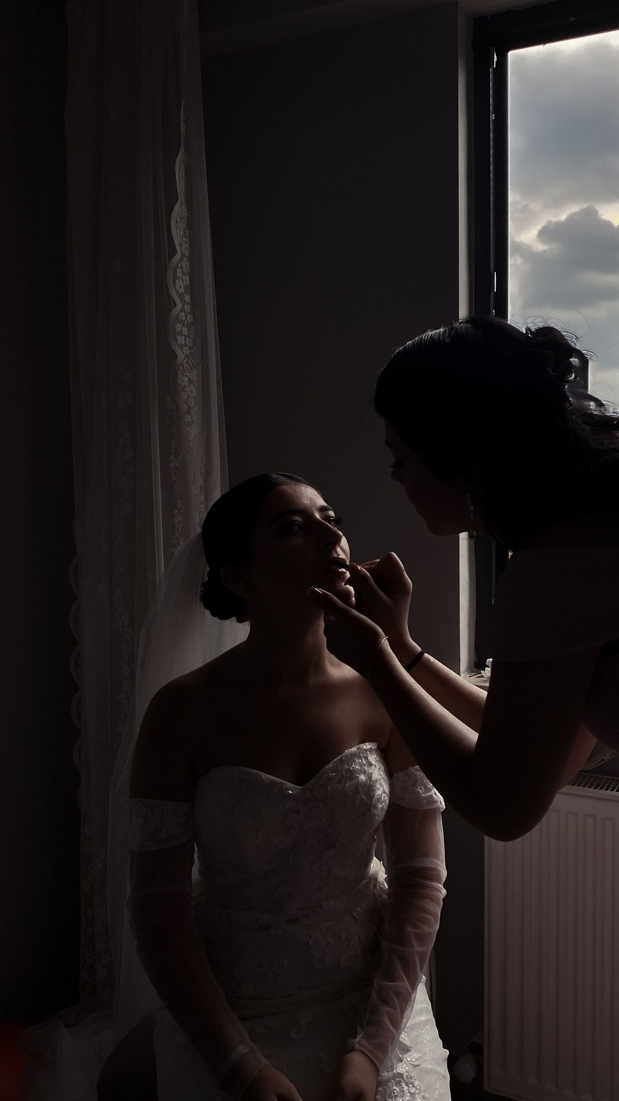 Preparativos de la novia junto a una ventana