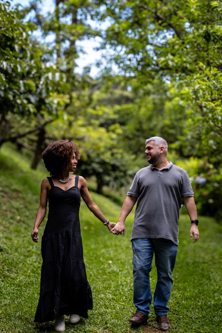 Couple Walking In The Park Holding Hands