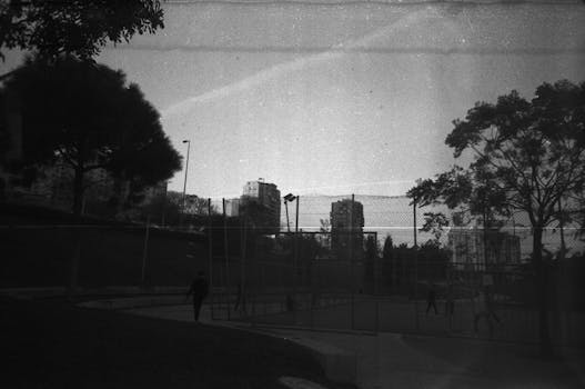 Black and white image of an urban sports court in Baku, Azerbaijan with silhouettes of people.