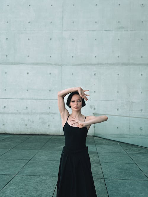 Woman in a Dance Pose Standing Among Concrete