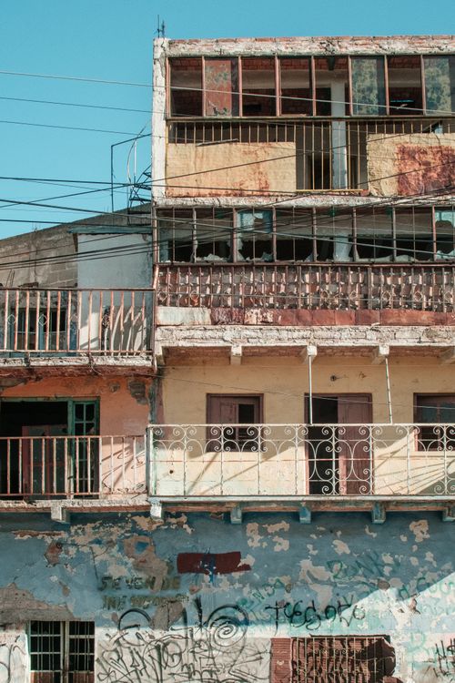 Free A decaying residential building with rusted balconies and graffiti, showcasing urban decay. Stock Photo