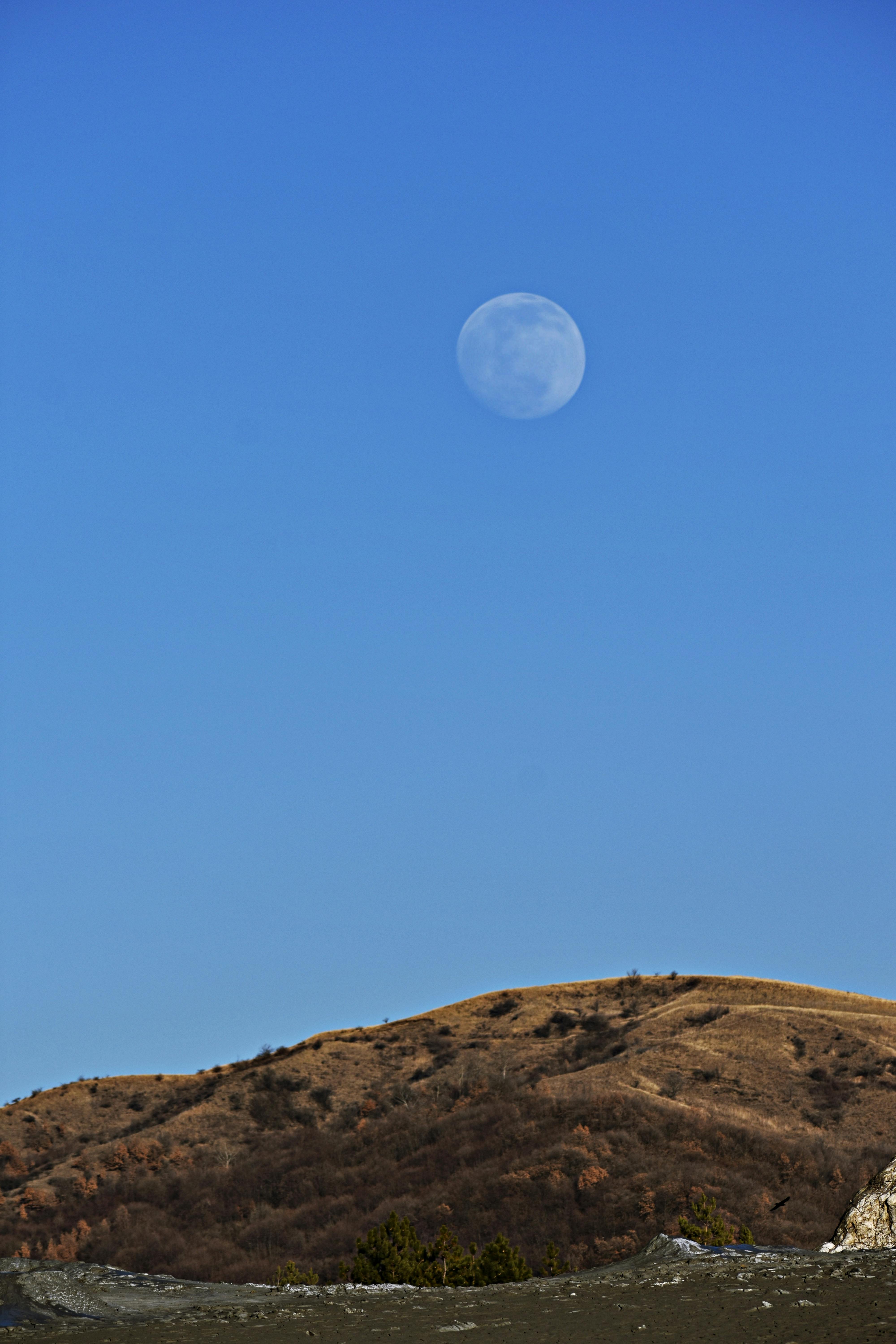 白天，在宁静的山景中捕捉月亮升起的美丽