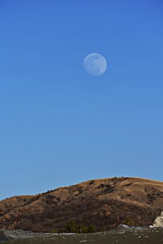 白天，在宁静的山景中捕捉月亮升起的美丽