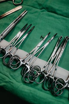 Close-up of surgical tools organized on a green cloth, highlighting medical equipment.