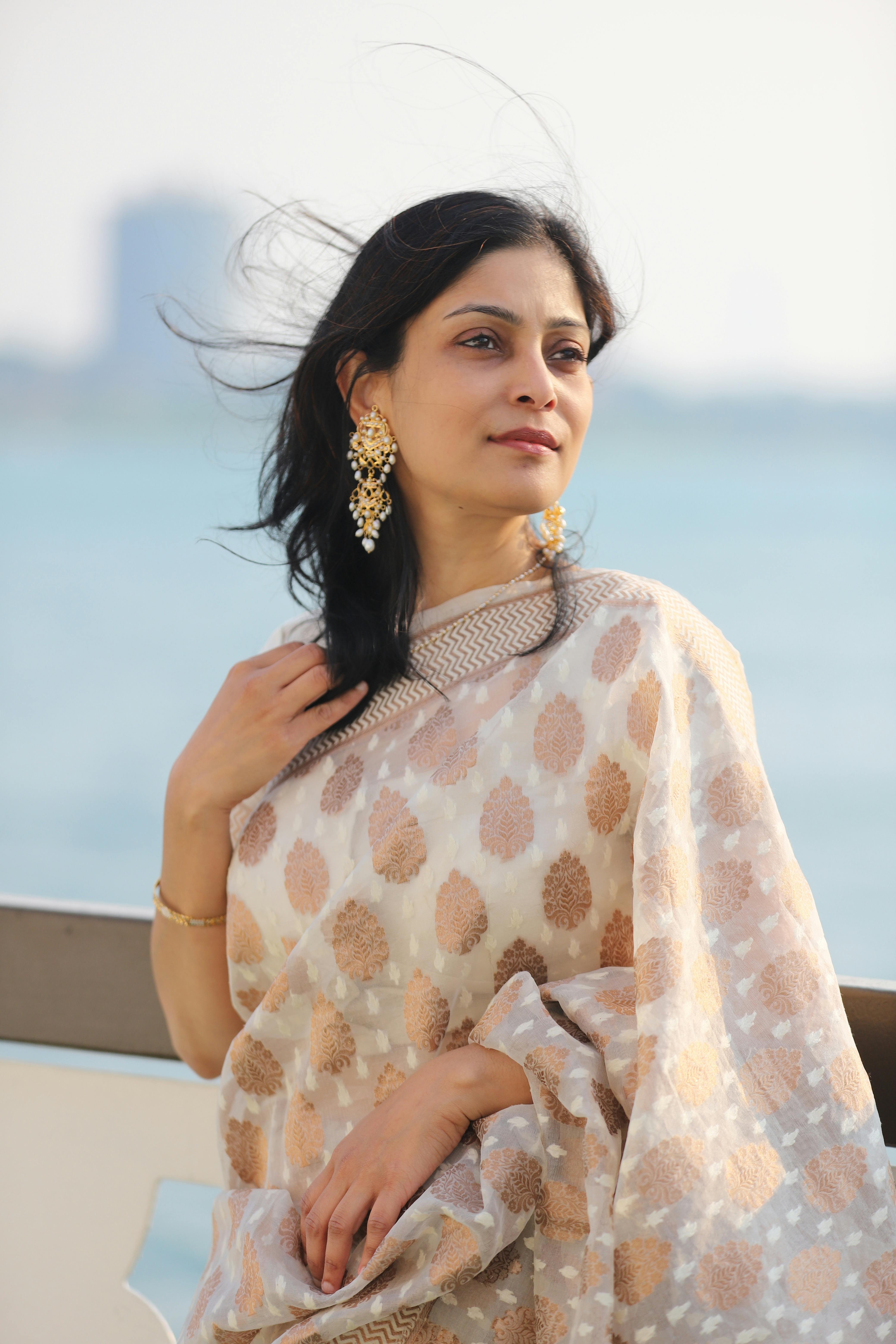 披肩的美丽女子在海边享受风日，展现出优雅与优雅