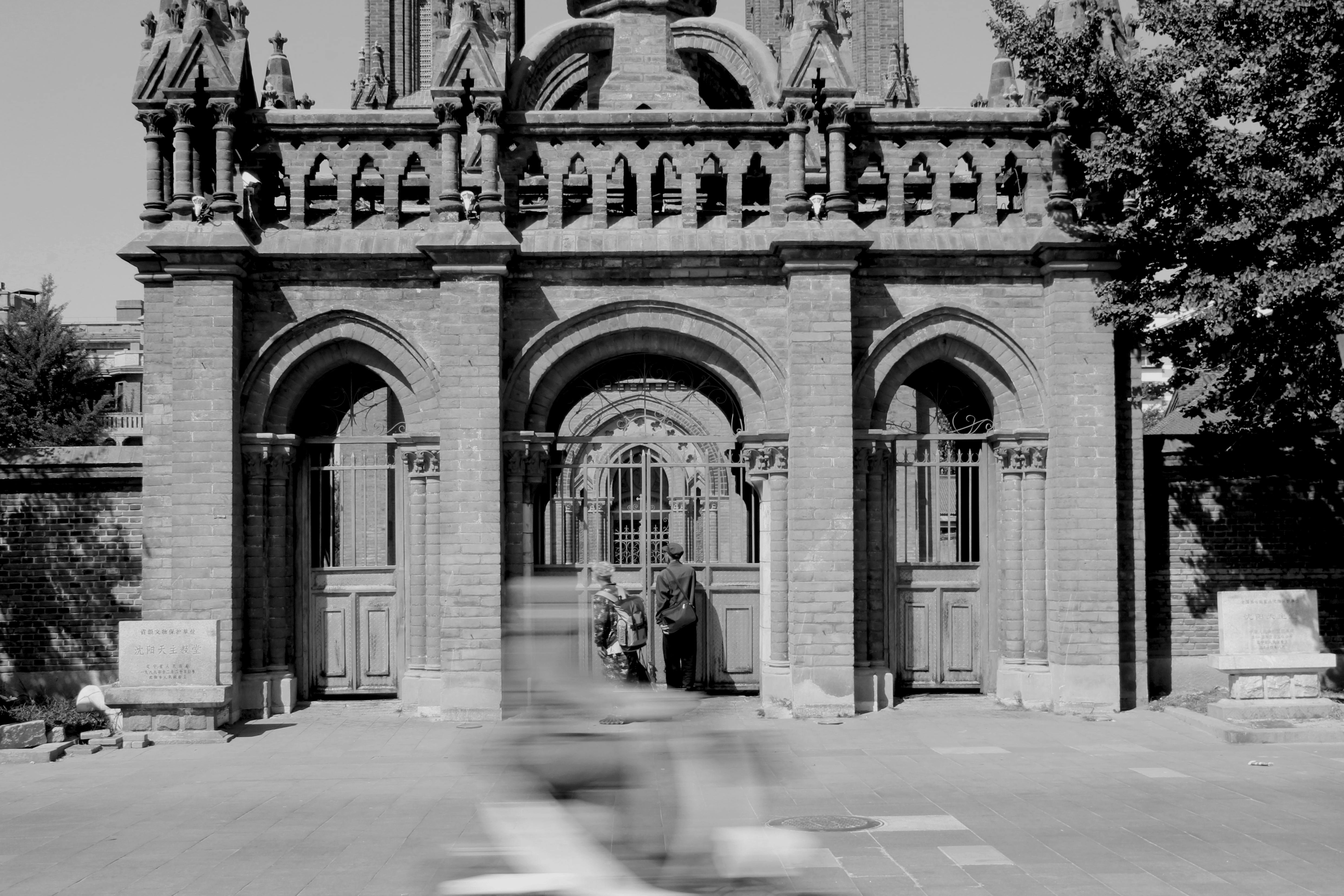 Monochrome image of a gothic facade in Shenyang, China with people and motion blur.