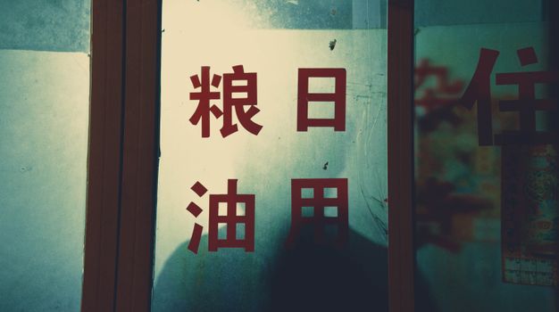 Glass panel featuring Chinese characters with a moody and vintage atmosphere.