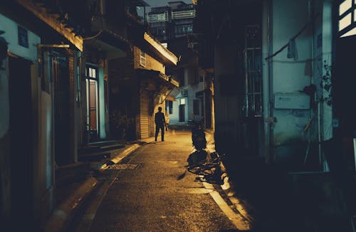 Person and Scooter in Dark Narrow Alley