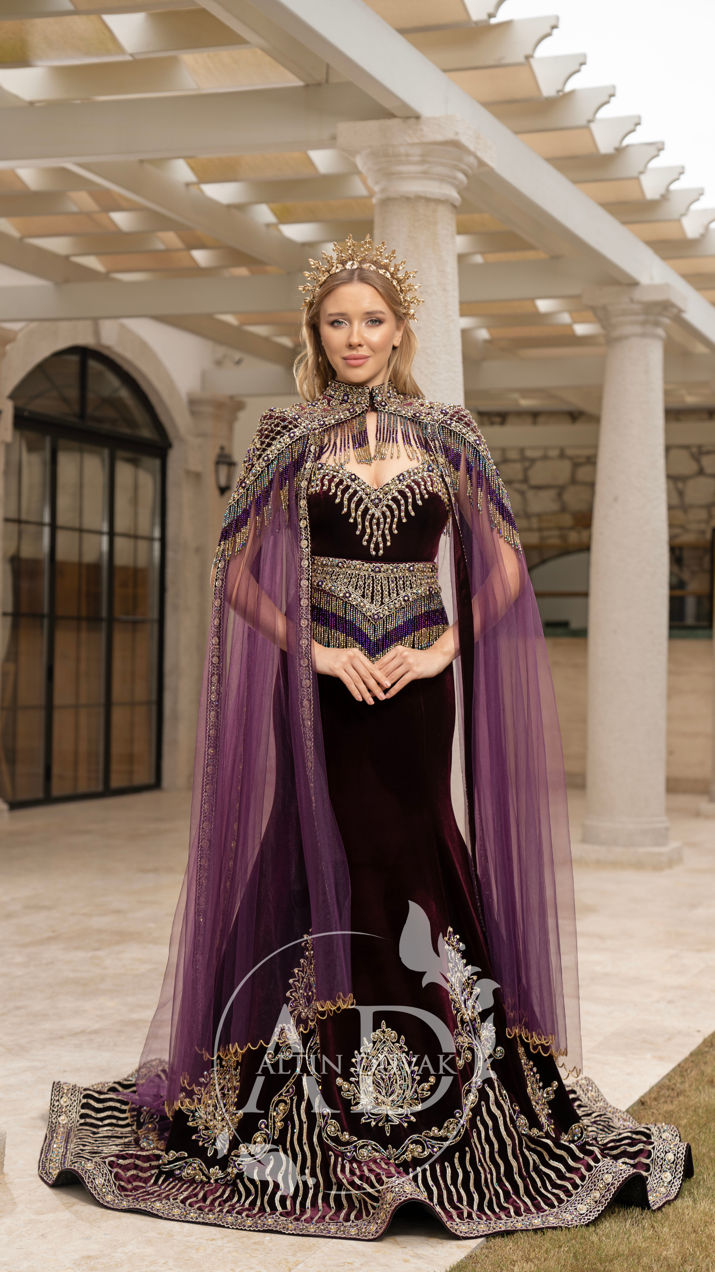 A luxurious fashion portrait showcasing a royal purple gown with intricate embellishments.